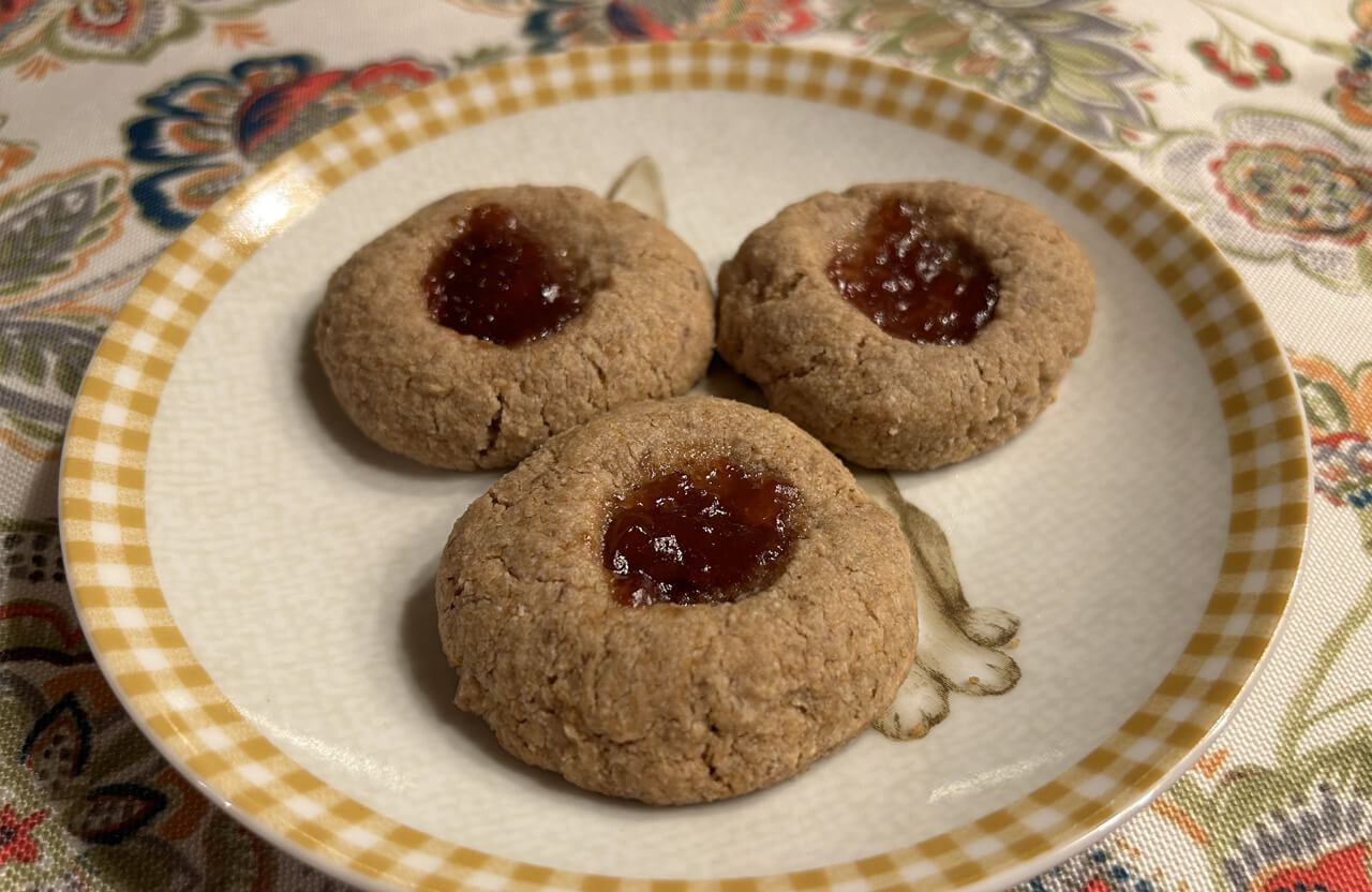 3 healthy, low sugar thumbprint cookies sit on a plate